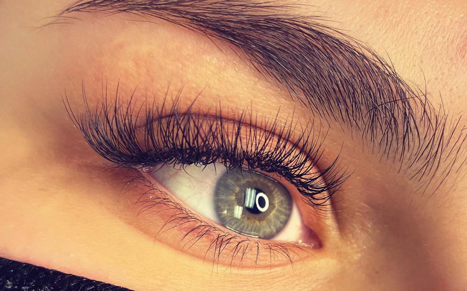 Œil avec des extensions de cils longues et recourbées, résultat d’une pose cil à cil